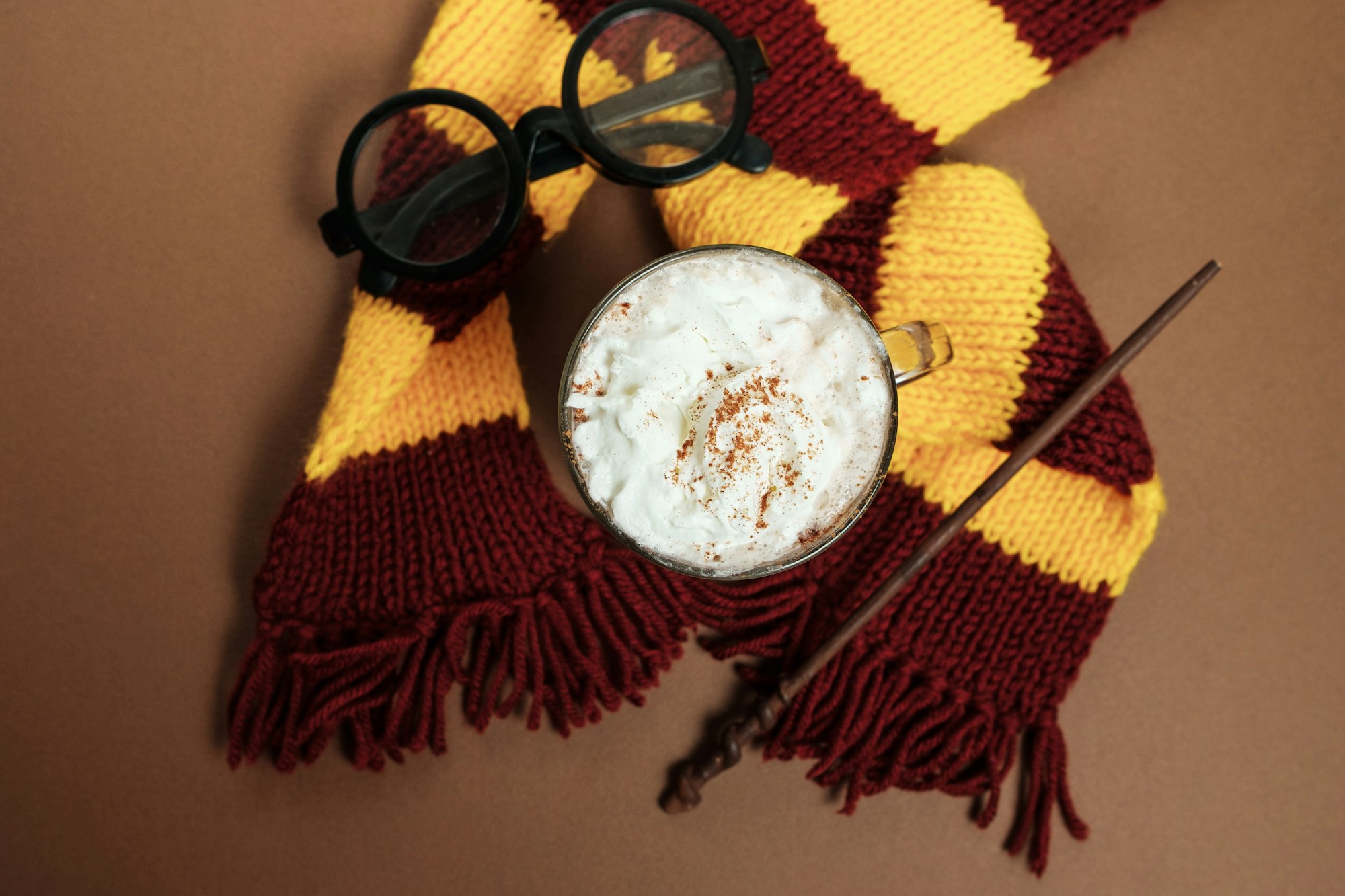 Magic composition with a cup of cocoa, a magic wand, a scarf on a vintage background
